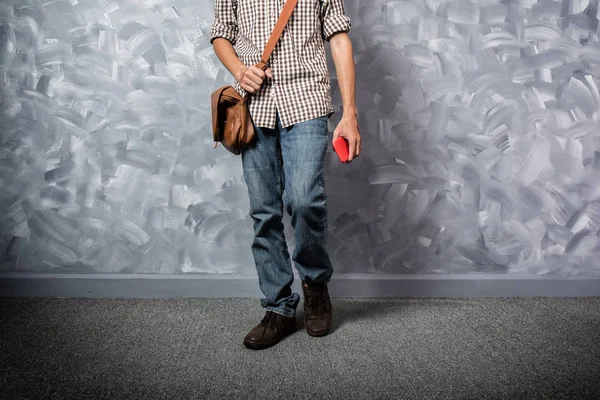 Vintage oda loft beton boya duvar arka planda hipster giyim tarzı ile Gezgin genç adam asya milliyet.