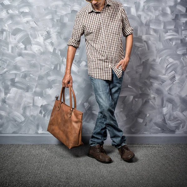 Vintage oda loft beton boya duvar arka planda hipster giyim tarzı ile Gezgin genç adam asya milliyet.