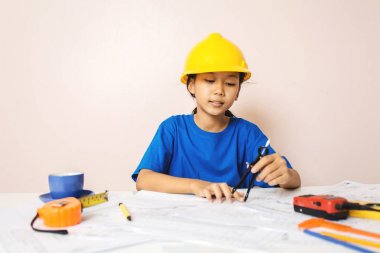 Yapı düzeni ve kask bir mühendis olarak oynayan Asyalı kız çocuk gülümseyen ve mutlu hafta sonları.