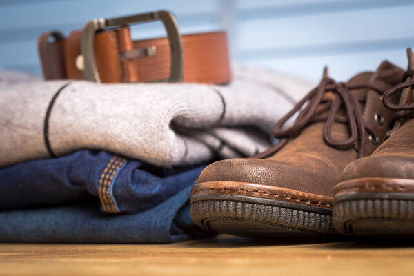 Men clothing asian style vintage with blue jeans pant and leather shoes in modern room with wooden table.