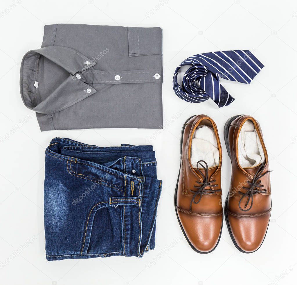Men's apparel, shirt, jean, brown shoes and necktie on white background, top view.