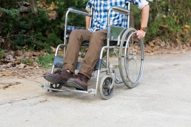 Genç adam yolda tekerlekli sandalye ile açık.