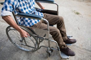 Genç adam yolda tekerlekli sandalye ile açık.