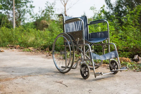 Cadeira de rodas na estrada de concreto, ao ar livre . — Fotografia de Stock
