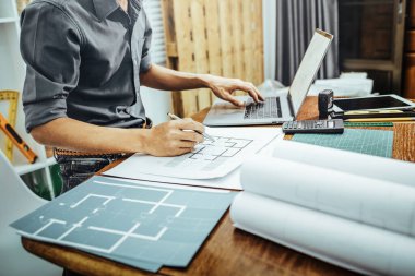 Yeni inşaat mimari taslak konsepti oluşturmak için kağıt ve planlarla çalışan mimar..