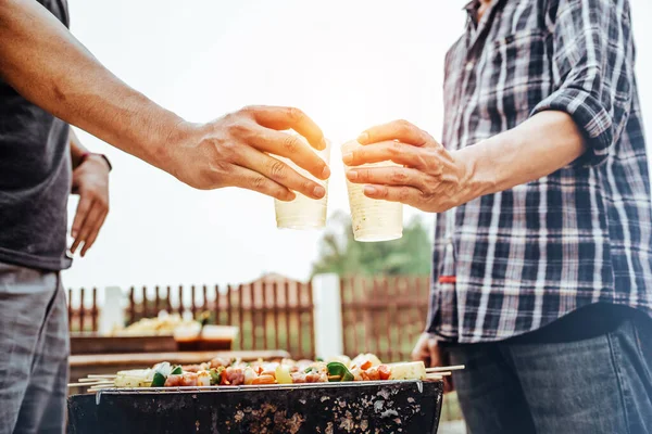 Happy man with friends making barbecue and drinking beer asian style.