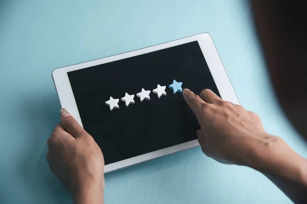 Woman hands give five star rating review on tablet.