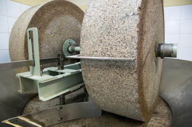 Grinding stone in olive oil factory clipart
