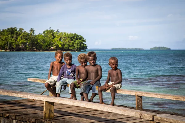 Gruppo di bambini seduti sul molo di legno, Isole Salomone — Foto Stock