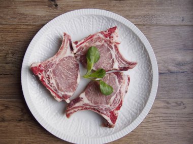 Ahşap arka plan üzerinde beyaz bir tabak içinde İber domuz pirzolası