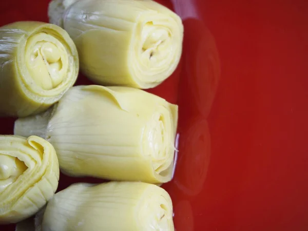 Hearts of artichokes in a red plate — Stock Photo, Image