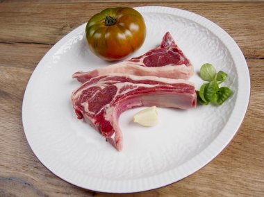 Domates ve sarımsak bir plaka ile iki kuzu pirzolası