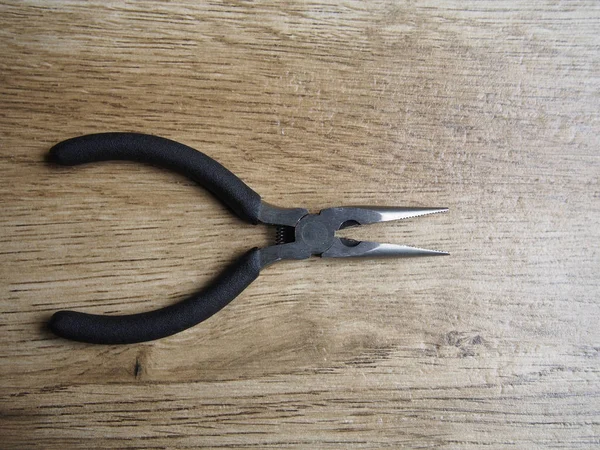 Open pliers on wood background — Stock Photo, Image