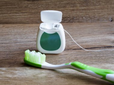 Ahşap arka plan üzerinde diş fırçası ve diş ipi