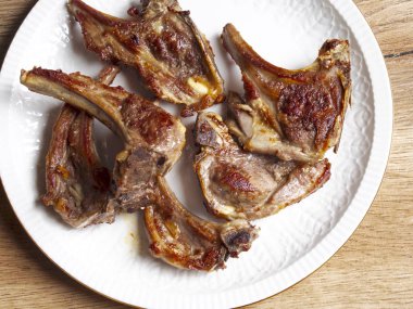 Beyaz bir tabak içinde pirzola kuzu pişmiş