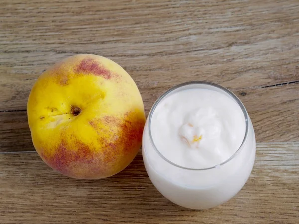Персиковий йогурт на фоні дерева — стокове фото