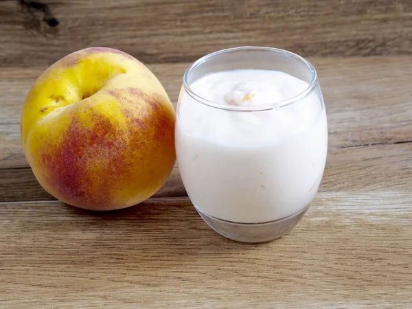 Персиковий йогурт на фоні дерева — стокове фото