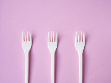 Pembe bir arka plan üzerinde plastik çatal şekli