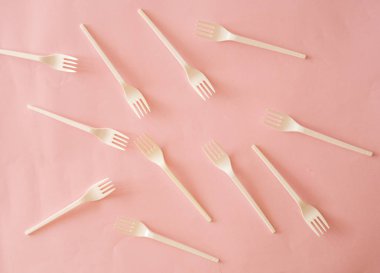 Pembe bir arka plan üzerinde plastik çatal şekli