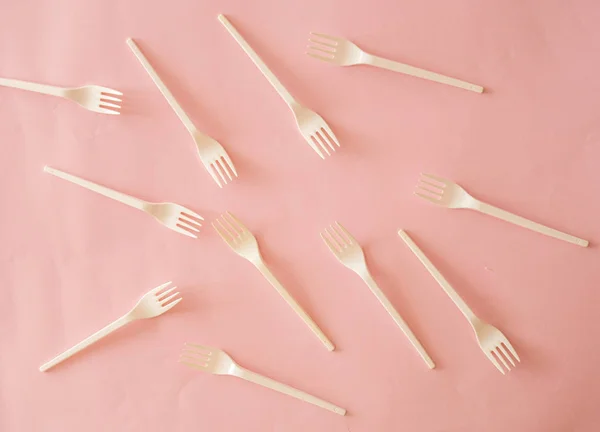 Plastic fork pattern on pink background