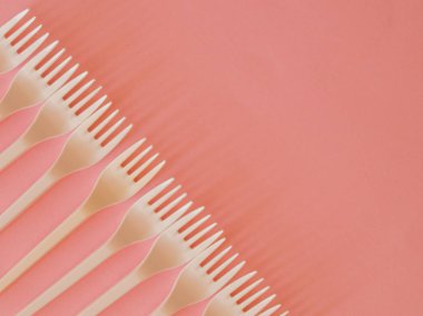 Pembe bir arka plan üzerinde plastik çatal şekli