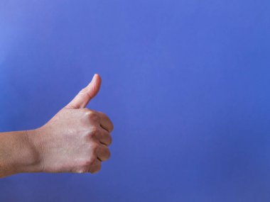 Thumb up on purple background with copy space