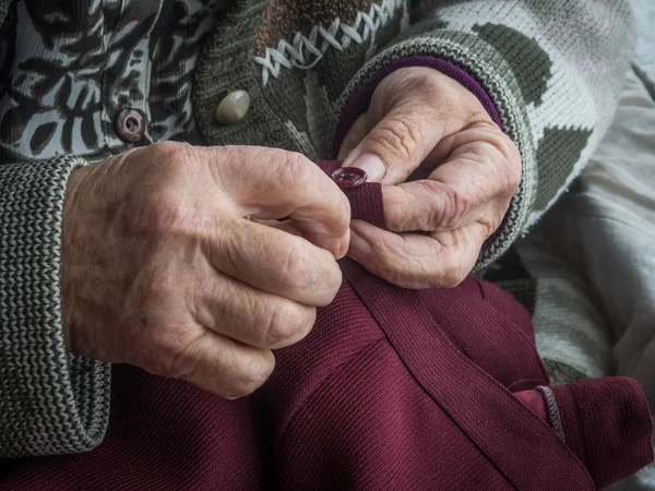 Χέρια ηλικιωμένης γυναίκας ράψιμο ενός κουμπιού — Φωτογραφία Αρχείου