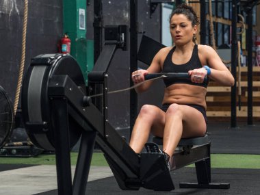 Spor salonunda kürek çeken bir kadın.