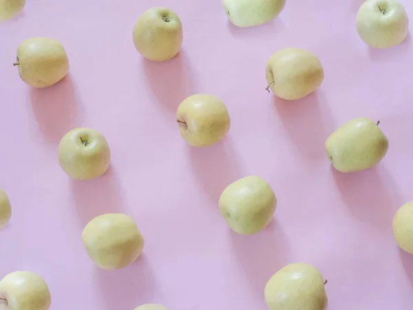 ピンクの背景に金色のリンゴのパターン — ストック写真