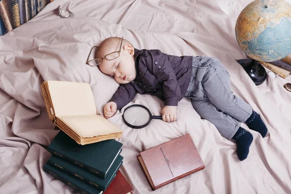 Zabawne dziecko śpi w okularach z książek i świata układu — Zdjęcie stockowe