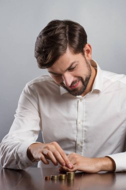 genç işadamı bir sikke sıra yığınları ile tutarak