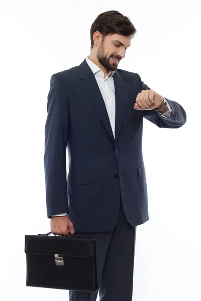 Atractivo hombre de negocios con maleta mira el reloj — Foto de Stock