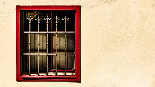Fenster mit rotem Rahmen und Metallgitter — Stockfoto
