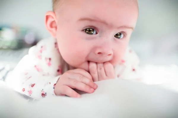 Baby Mädchen auf einem Bett schaut in die Kamera — Stockfoto