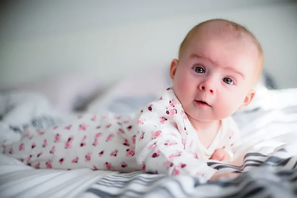 Baby Mädchen auf einem Bett schaut in die Kamera — Stockfoto