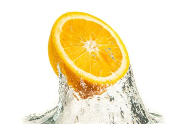 Portakalın yarısı suya sıçrıyor ve beyaz arka planda izole bir şekilde batıyor. Citrus içeceği konsepti.