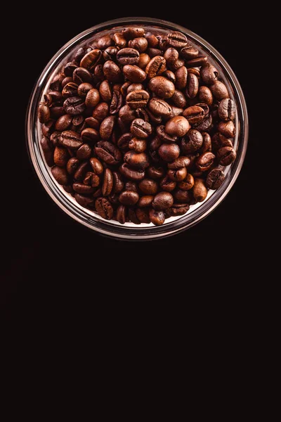 Coffee beans in glass jar standing on black background. — Stock Photo, Image