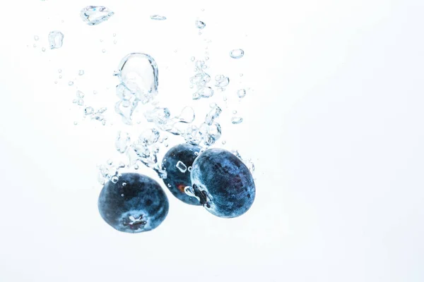 一种带气泡白色背景的有机蓝莓沉入水中。 宏观细节特写. — 图库照片