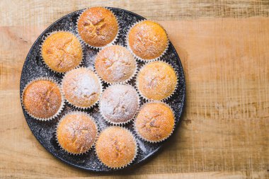 Tahta masada beyaz şeker tozlu ev yapımı elmalı kekler.