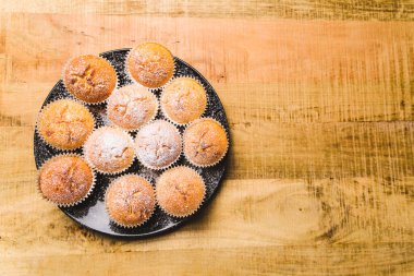 Tahta masada beyaz şeker tozlu ev yapımı elmalı kekler.