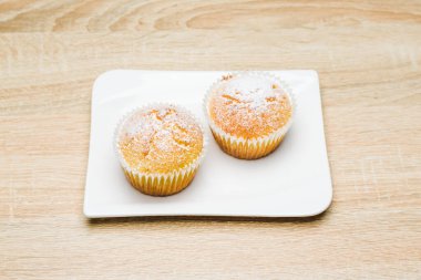 Tahta masada beyaz şeker tozlu ev yapımı elmalı kekler.