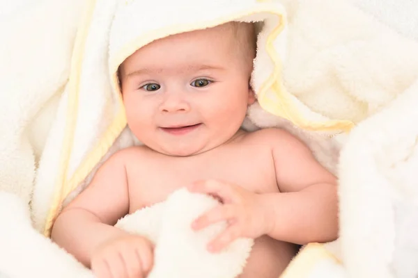 Entzückende 6 Monate alte Säugling auf einem Bett auf dem Bauch mit dem Kopf nach oben in die Kamera blickend mit ihren großen Augen. natürliches Licht. — Stockfoto