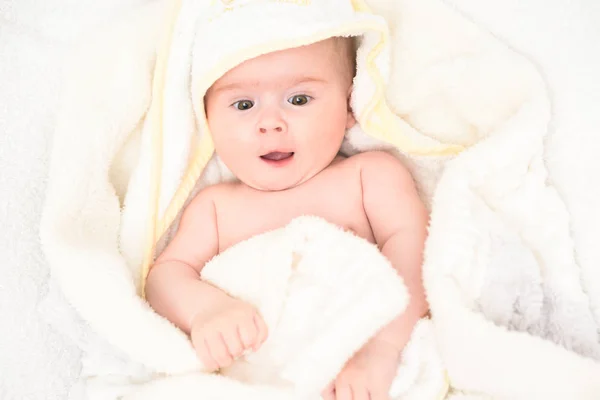 Roztomilé 6 měsíců Baby dívka nemluvně na posteli na břiše s hlavou nahoru dívá do kamery s velkýma očima. Přírodní světlo. — Stock fotografie