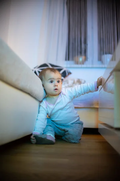 11-месячная девочка смотрит телевизор как загипнотизированная. Концепция проблем здравоохранения и развития . — стоковое фото