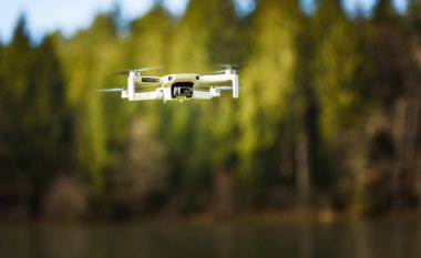 Graz, Avusturya - 29 Aralık 2019. Dji Mavic Mini insansız hava aracı dondurucu kış gününde donmuş gölün üzerinde uçuyor.