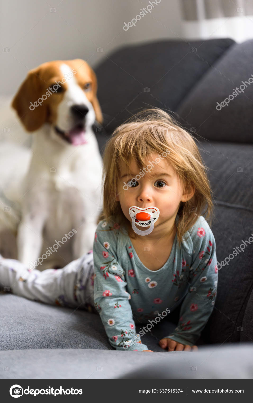 Cute 2 year old Baby girl on a bed on her belly with head up looking