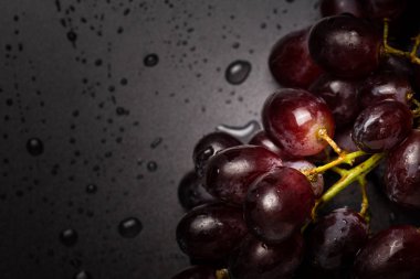 Close up of red grapes on black background with copy space.