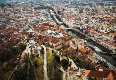 Avusturya 'daki Graz Hill Schlossberg' den hava manzarası, evlerin çatıları, Murat Nehri ve turistik şehrin tüm ünlü manzaraları ile şehir manzarası. Yukarıdan İHA atışı.