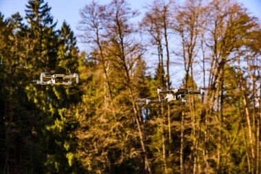 Graz, Avusturya 15.03.2020 - DJI Drones Maviç mini ve Mavic 2 Pro birlikte uçuyorlar. Boyut farkı. Mavi gökyüzüne karşı. Boşluğu kopyala
