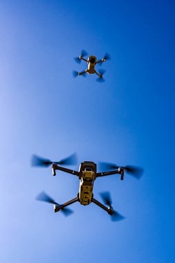 Graz, Avusturya 15.03.2020 - DJI Drones Maviç mini ve Mavic 2 Pro birlikte uçuyorlar. Boyut farkı. Mavi gökyüzüne karşı. Boşluğu kopyala